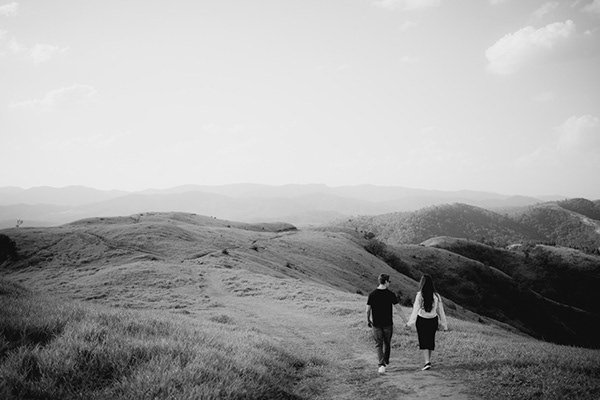 Vic e Dimi caminhando em uma paisagem aberta